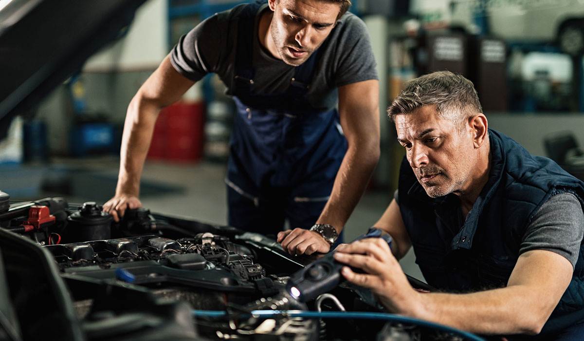 two mechanics working on a car